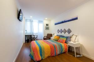 a bedroom with a bed with a colorful striped bedspread at Cozy place in Lisbon 23 in Lisbon