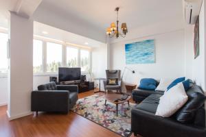 a living room with a couch and chairs and a tv at Cozy place in Lisbon 23 in Lisbon