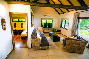 a living room with a couch and chairs and a bed at Qamea Resort & Spa in Qamea