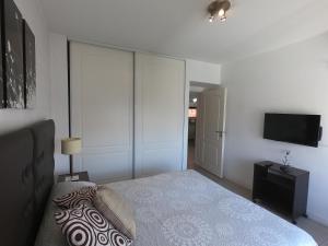 a bedroom with a bed and a tv on a wall at Rent Apart Caballito in Buenos Aires