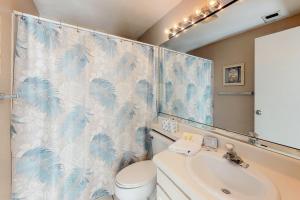 a bathroom with a blue and white shower curtain and a sink at Forest Beach Villas in Hilton Head Island