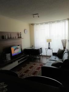 sala de estar con sofá y mesa en Apartamento Portal Pacífico, en La Serena