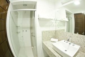 a white bathroom with a sink and a shower at Hotel Cantelle in Frederico Westphalen +41 photos