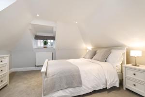 a white bedroom with a bed and two night stands at Gorgeous Apartment in the centre of Winchester in Winchester