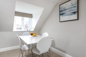 a white dining room with a white table and chairs at Gorgeous Apartment in the centre of Winchester in Winchester