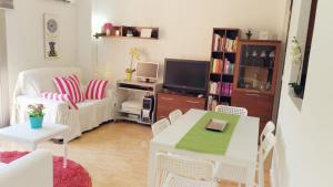 uma sala de estar com uma mesa e uma televisão em Central Apartment in Valencia with WIFI + Parking. em Valência