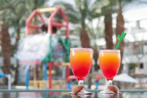 two glasses of orange juice sitting on top of a table at Leonardo Club Eilat - All Inclusive in Eilat