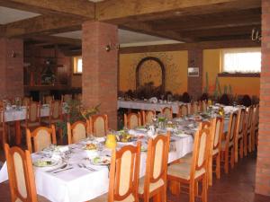 a dining room with a long table with white tables and chairs at Siedlisko Agroturystyczne in Mrągowo +39 photos