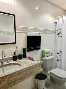 ein weißes Bad mit einem Waschbecken und einem WC in der Unterkunft Ecopousada Garten Haus in Santa Teresa