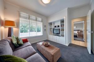 a living room with a couch and a television at Mews Cottages in Gisborne