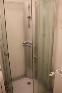 a shower with a glass door in a bathroom at Affären Må Bra in Sunne