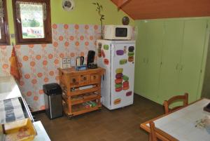 La cuisine est équipée d'un réfrigérateur blanc et d'un four micro-ondes. dans l'établissement La Sapotine, à Étrembières