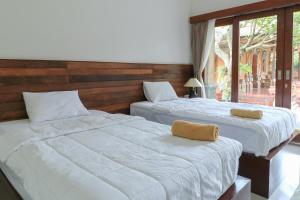 Postel nebo postele na pokoji v ubytování Yuliati House Ubud