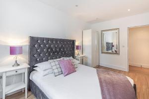a bedroom with a large bed and a mirror at Knightsbridge Dream Apartment in London