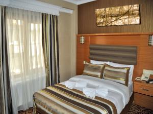 A bed or beds in a room at Alfa Hotel