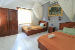 Postel nebo postele na pokoji v ubytování Yuliati House Ubud