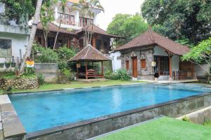 a swimming pool in front of a house at Yuliati House in Ubud