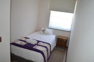 a small bedroom with a bed and a window at Departamento Concepción III in Concepción