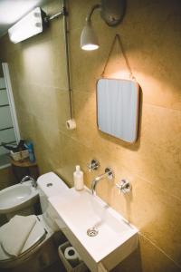 ein Bad mit einem Waschbecken und einem Wandspiegel in der Unterkunft Asul B&B in Lissabon