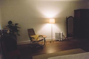 Habitación con lámpara, silla y mesa. en Asul B&B, en Lisboa