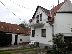 a white house with a balcony and a yard at Valentin ház in Szentendre