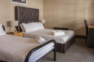 a hotel room with two beds with white towels at Campsie Hotel in Sydney