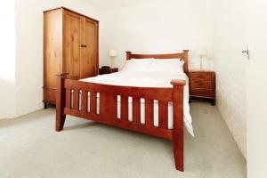 een slaapkamer met een houten bed en een houten kast bij Beehive 14 in Mount Buller