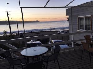balcón con mesa y sillas y la playa en Costanera los Molinos, en Valdivia