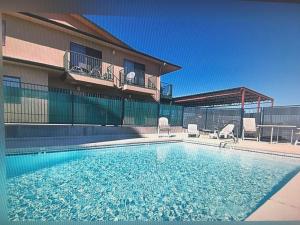 une piscine avec deux chaises et un bâtiment dans l'établissement COPPER STAY INN Benson AZ I-10 Exit 304, à Benson