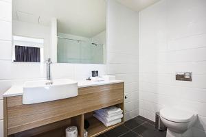 Mantra MacArthur Hotel في كانبرا: حمام مع حوض ومرحاض