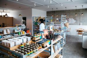 a man standing in a store with a display of bottles at Iwashi Building Hostel in Akune