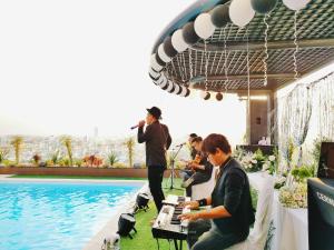 芹苴的住宿－假日一芹苴酒店，一群人在游泳池前播放音乐