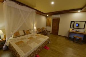a bedroom with a bed and a desk and a television at Ann Heritage Lodge in Ywama