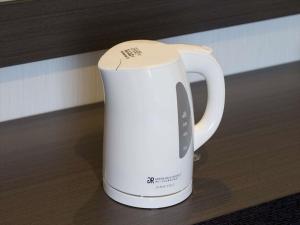 a white coffee pot sitting on a table at GR Hotel Ginzadori in Kumamoto