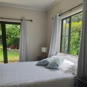 a bedroom with a bed and a large window at Accommodation at Lakeside in Oamaru