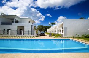 a villa with a swimming pool in front of a house at 1949 Dreamy Home in Panglao Island