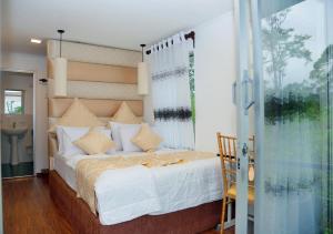 een slaapkamer met een groot bed en een raam bij Box on clouds in Ella
