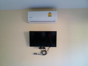 TV en la pared con aire acondicionado en Palm Kaew Resort Krabi, en Krabi