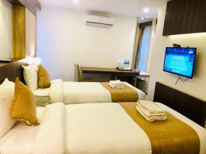 Ένα ή περισσότερα κρεβάτια σε δωμάτιο στο The Milestone Hotel
