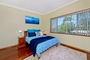 a bedroom with a bed and a large window at Salt Breeze in Lake Cathie