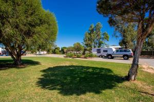 a rv parked in a park with a tree at BIG4 Shepparton Park Lane Holiday Park in Shepparton