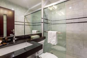 a bathroom with a sink and a glass shower at The L Hotel, Ascend Hotel Collection in Brooklyn
