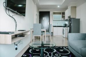 Una sala de estar con una mesa de cristal y un sofá. en 2BR Deluxe and Modern Menteng Park Apartment By Travelio, en Yakarta