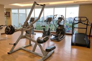 Un gimnasio con varias bicicletas estáticas en una habitación. en 2BR Deluxe and Modern Menteng Park Apartment By Travelio, en Yakarta