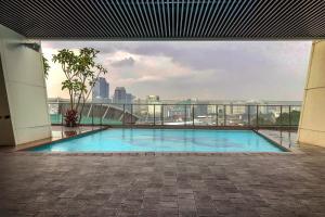 una piscina en un edificio con vista a la ciudad en 2BR Deluxe and Modern Menteng Park Apartment By Travelio, en Yakarta