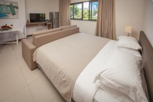 a bedroom with a large white bed and a desk at Coral Bay by Dream Escapes in Blue Bay