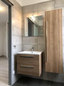 ein Badezimmer mit Waschbecken und Spiegel in der Unterkunft L'ESTUAIRE in Le Havre