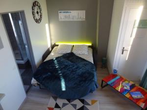 een kleine slaapkamer met 2 bedden en een klok aan de muur bij L'ESTUAIRE in Le Havre