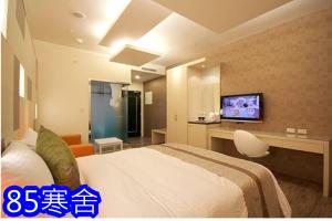 um quarto de hotel com uma cama e uma televisão de ecrã plano em 85涵舍旅宿 em Kaohsiung