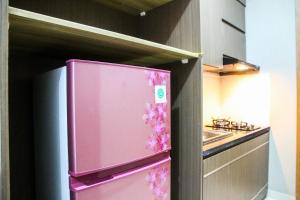 a pink refrigerator with flowers on the door in a kitchen at New Studio The Oasis Apartment By Travelio in Cikarang